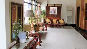 A spacious lobby with a high ceiling, a seating area with patterned sofas, a coffee table, and a mirror. - Maxandrea Hotel (Cagayan de Oro)