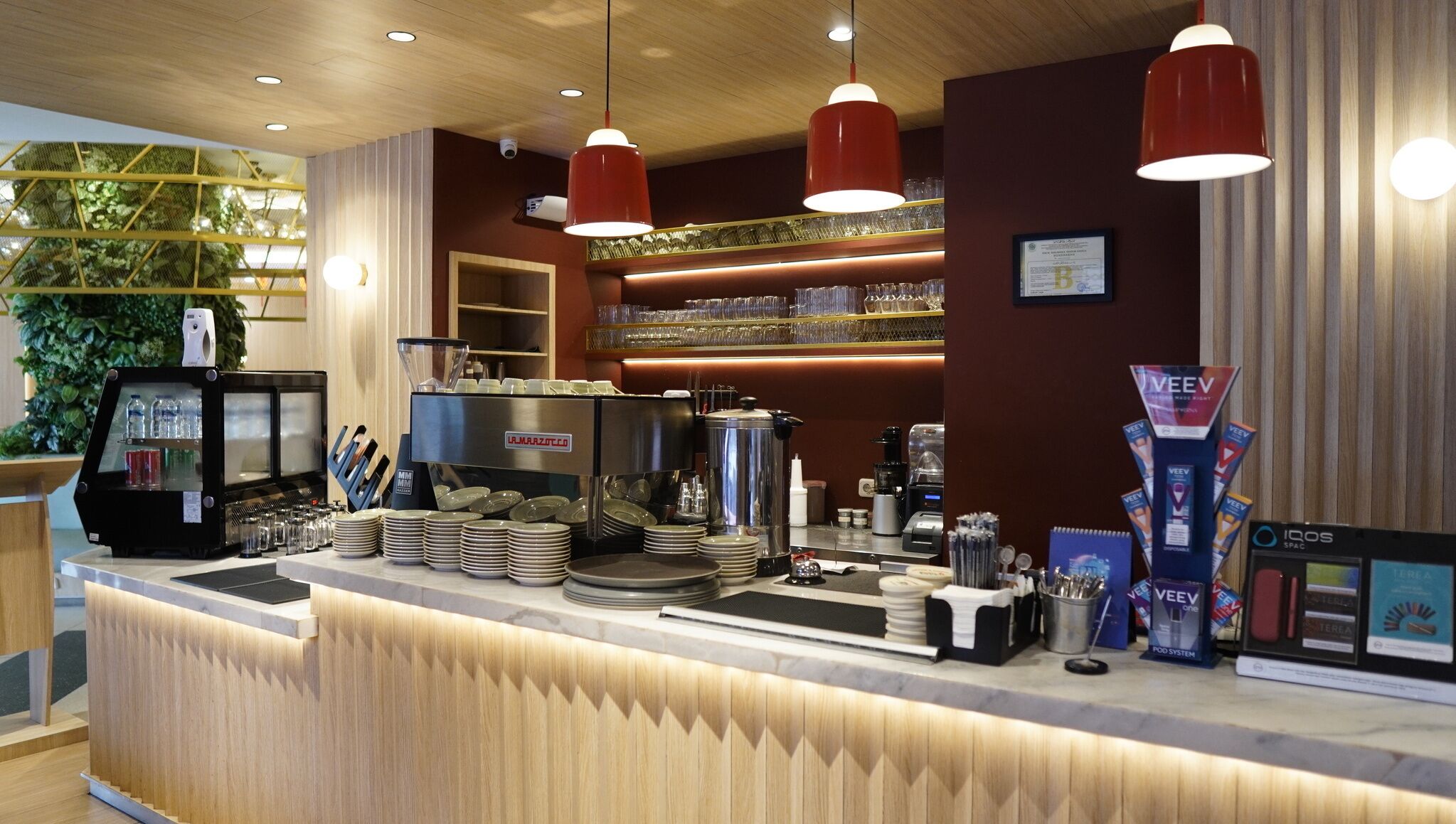 Een koffiebar met een toonbank, koffieapparatuur en diverse bekers en borden.