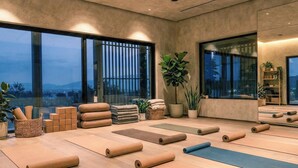 A spacious room with large windows, yoga mats, and a view of the cityscape. - Zante Maris Suites - Adults Only (Zakynthos)