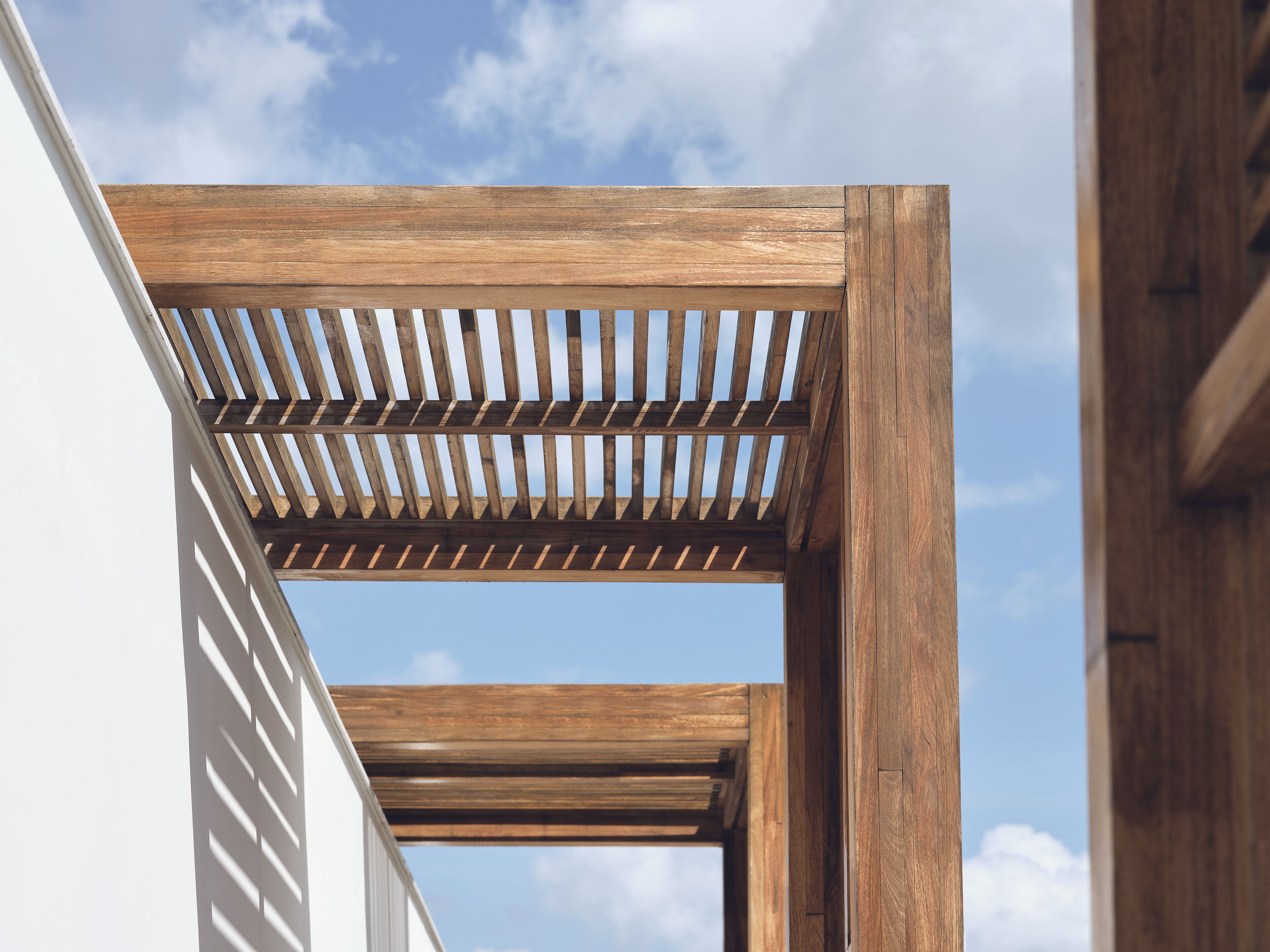 A wooden pergola structure against a clear sky.