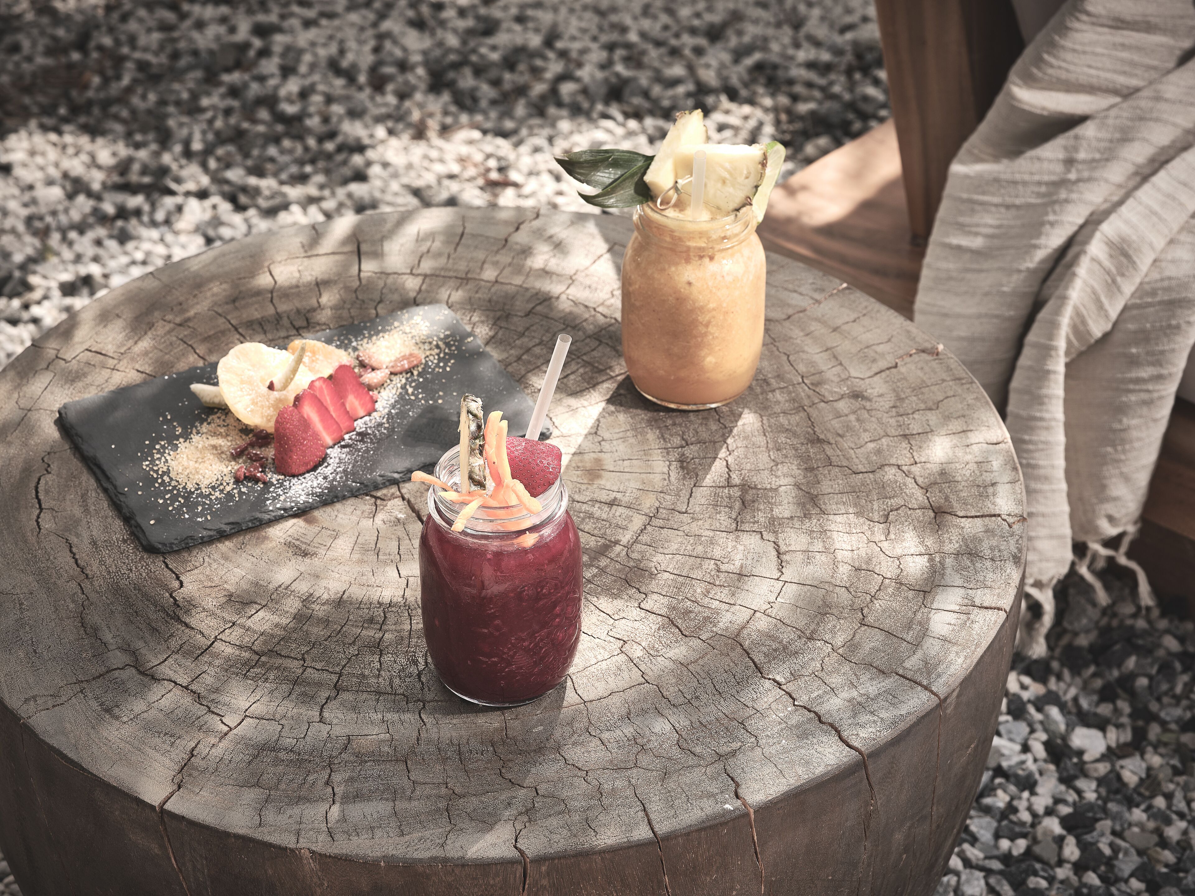 Une table en bois rustique, avec trois boissons et une assiette de dessert.