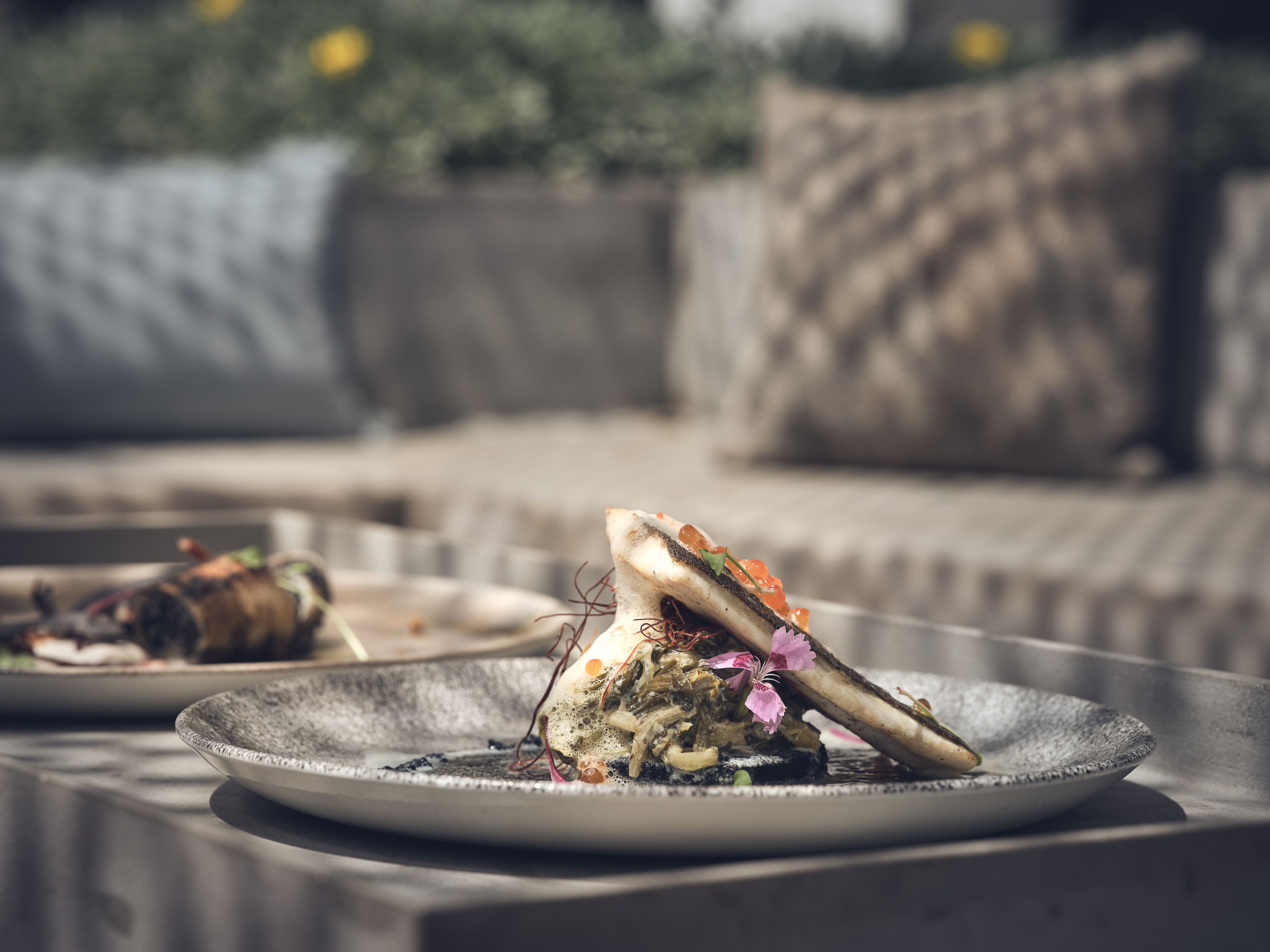 Une table à manger avec des assiettes remplies de nourriture, un canapé en arrière-plan et un coussin.
