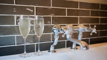 A bathroom with a modern faucet and two glasses of water on the sink.