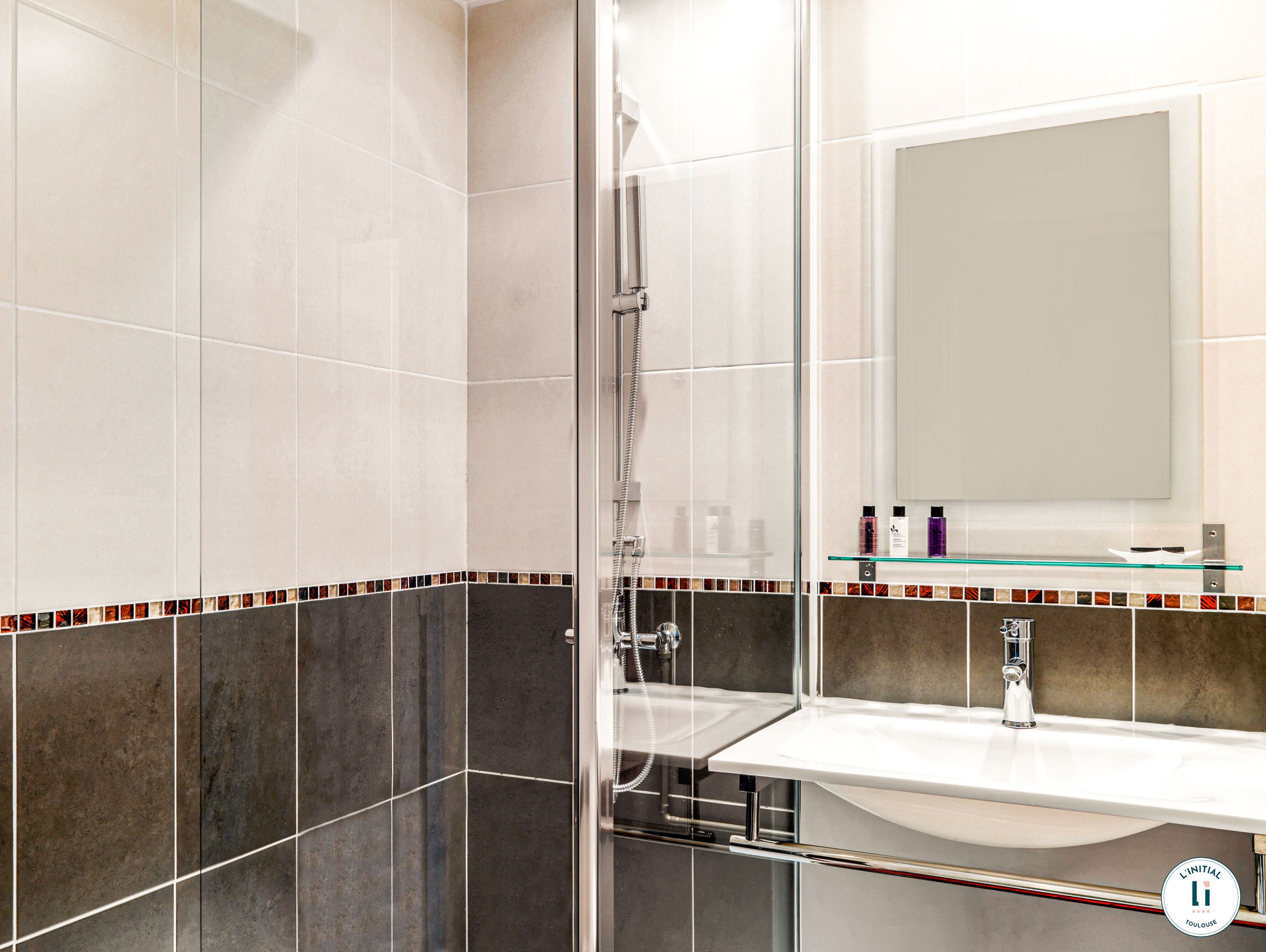 Un baño con ducha de vidrio, lavamanos blanco y espejo arriba.