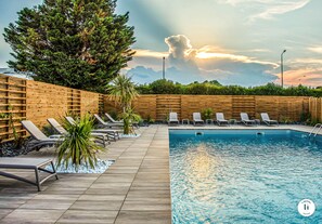 Un espace piscine avec des chaises longues et une clôture en bois.