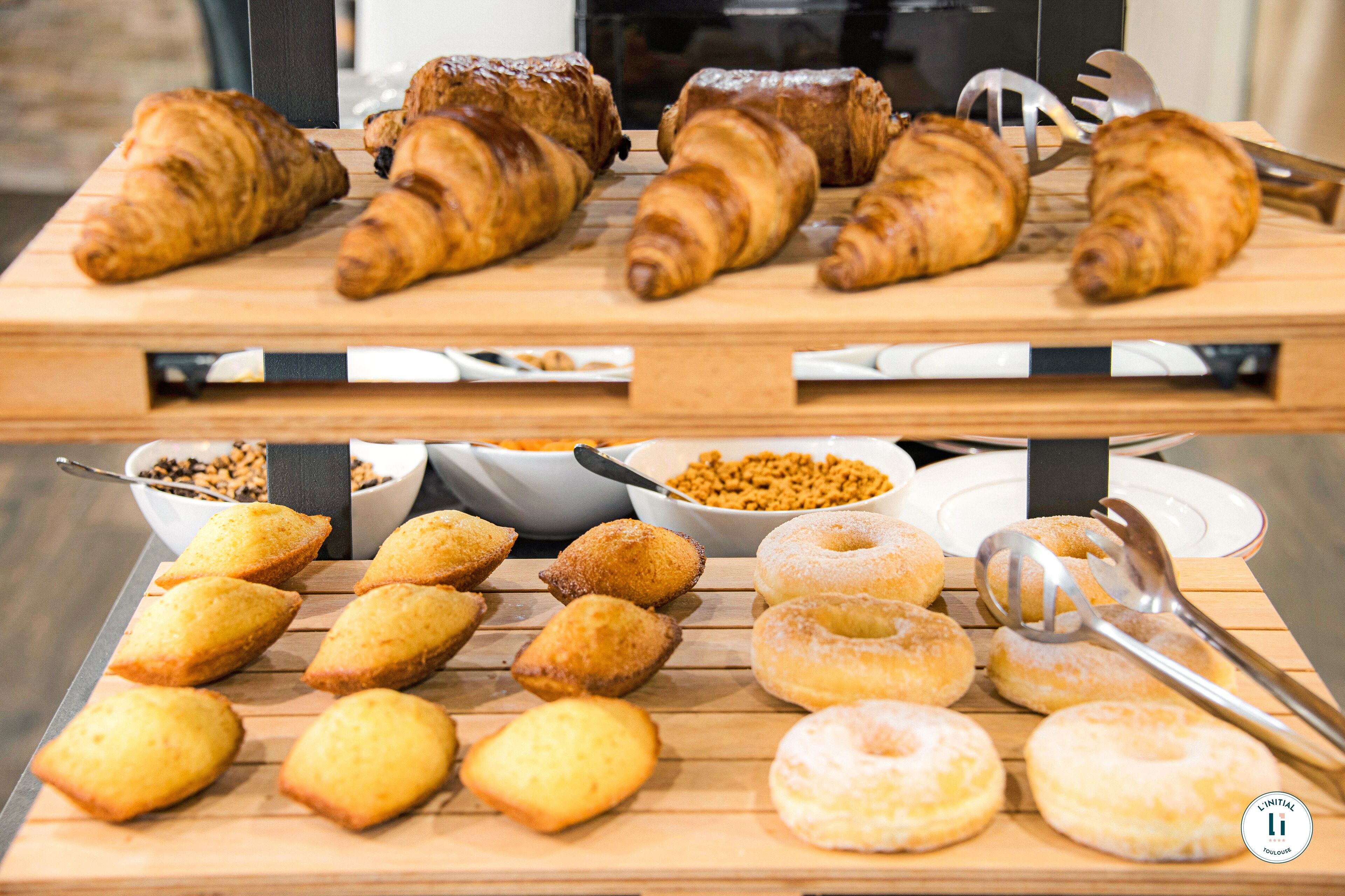 Diversas pastas y productos de repostería expuestos sobre tablas de madera.