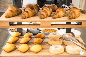 A variety of pastries and baked goods displayed on wooden boards.