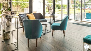 Un interior moderno con un sofá, dos sillones, una mesita y un globo decorativo.