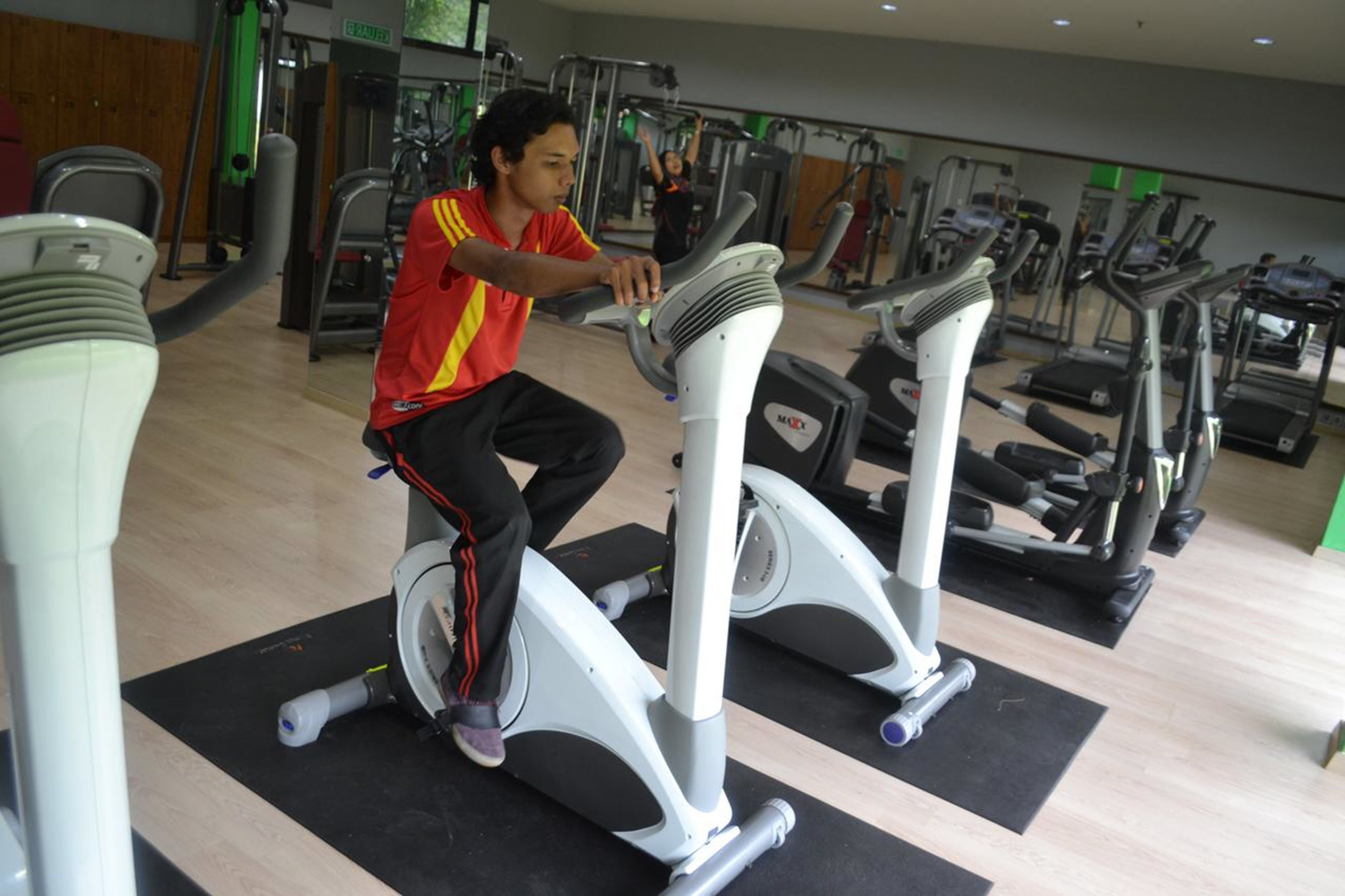 A gym with various exercise equipment, including treadmills and elliptical machines.