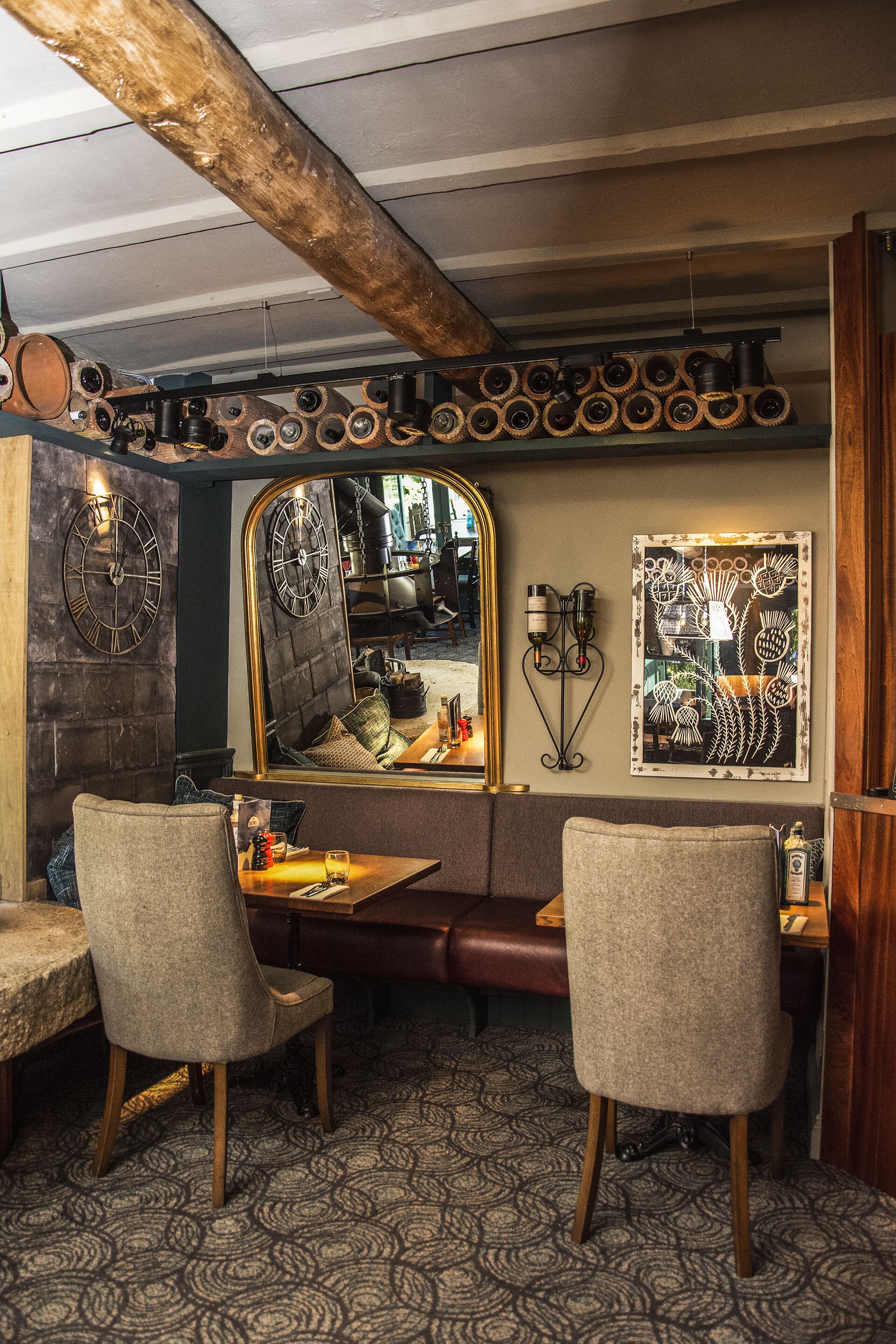 Interior acollidor d'un restaurant amb sostre de fusta, un mosaic de moqueta i un gran mirall que reflecteix la zona de dinar.