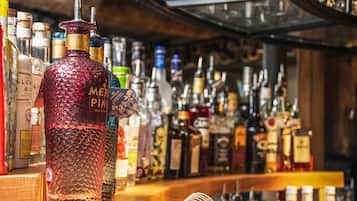 Un bar con una variedad de botellas de licor, incluyendo una botella destacada etiquetada como "MER PINK".