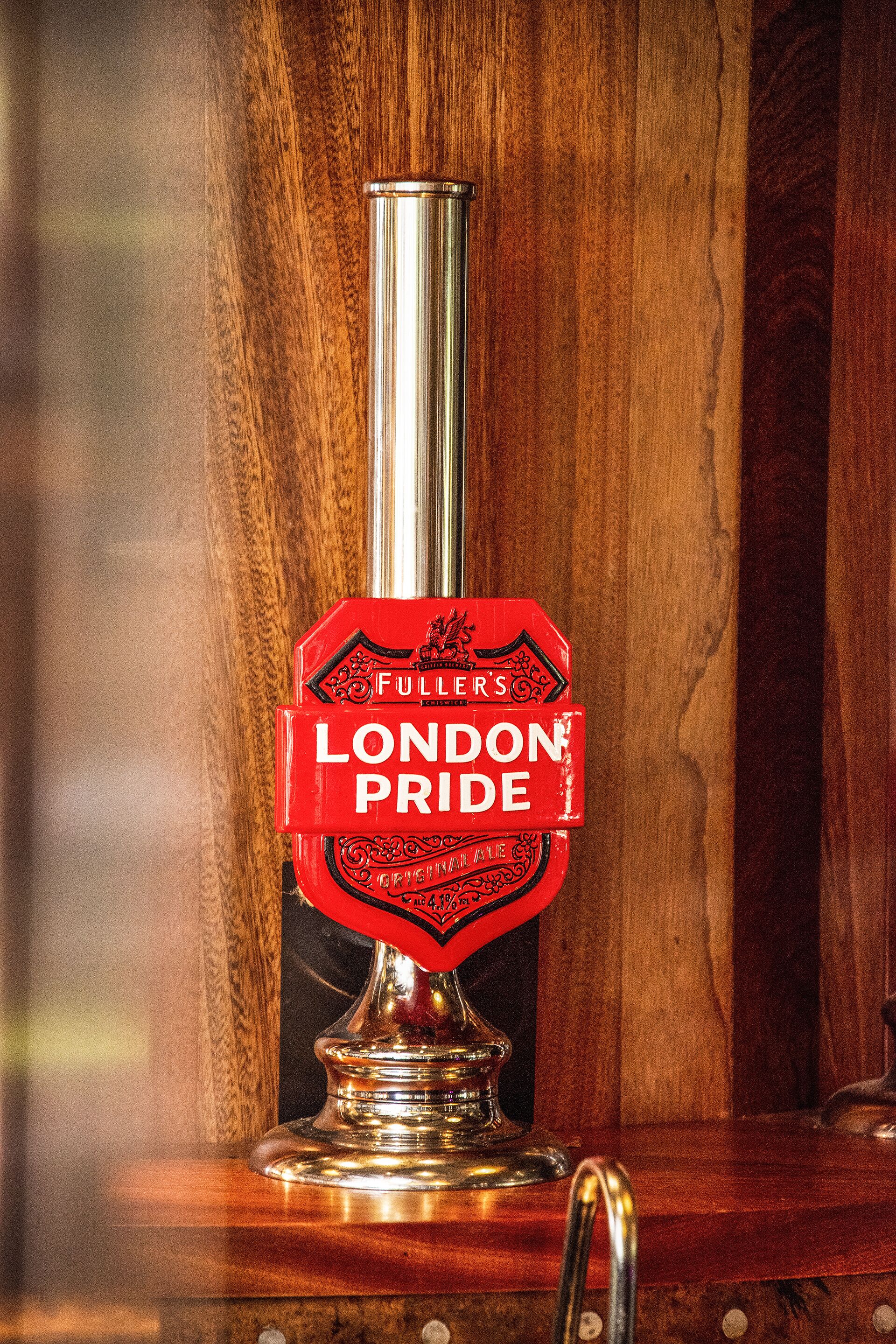 Un grifo con la etiqueta 'LONDON PRIDE' sobre una superficie de madera.