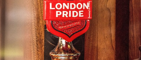Un grifo con la etiqueta 'LONDON PRIDE' sobre una superficie de madera.