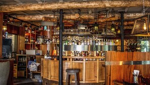 A bar area with wooden shelves, bottles, and a patterned floor. - The Old Mill (Lymington)