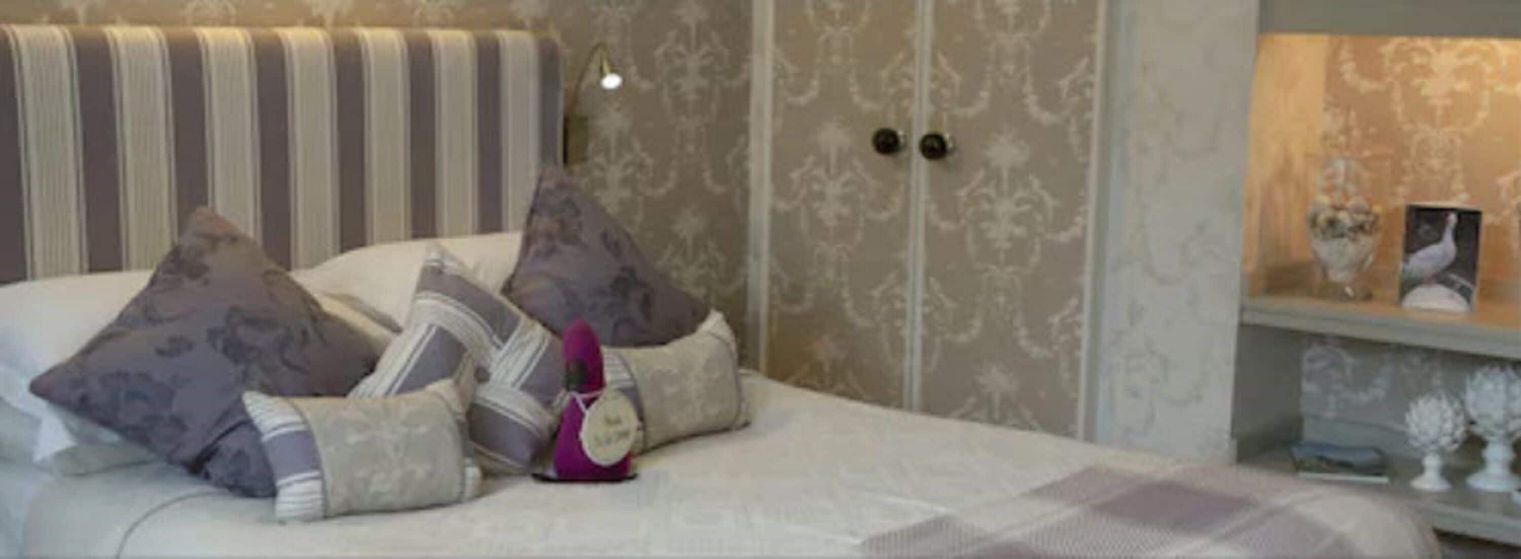 A neatly made bed with striped headboard and multiple pillows.