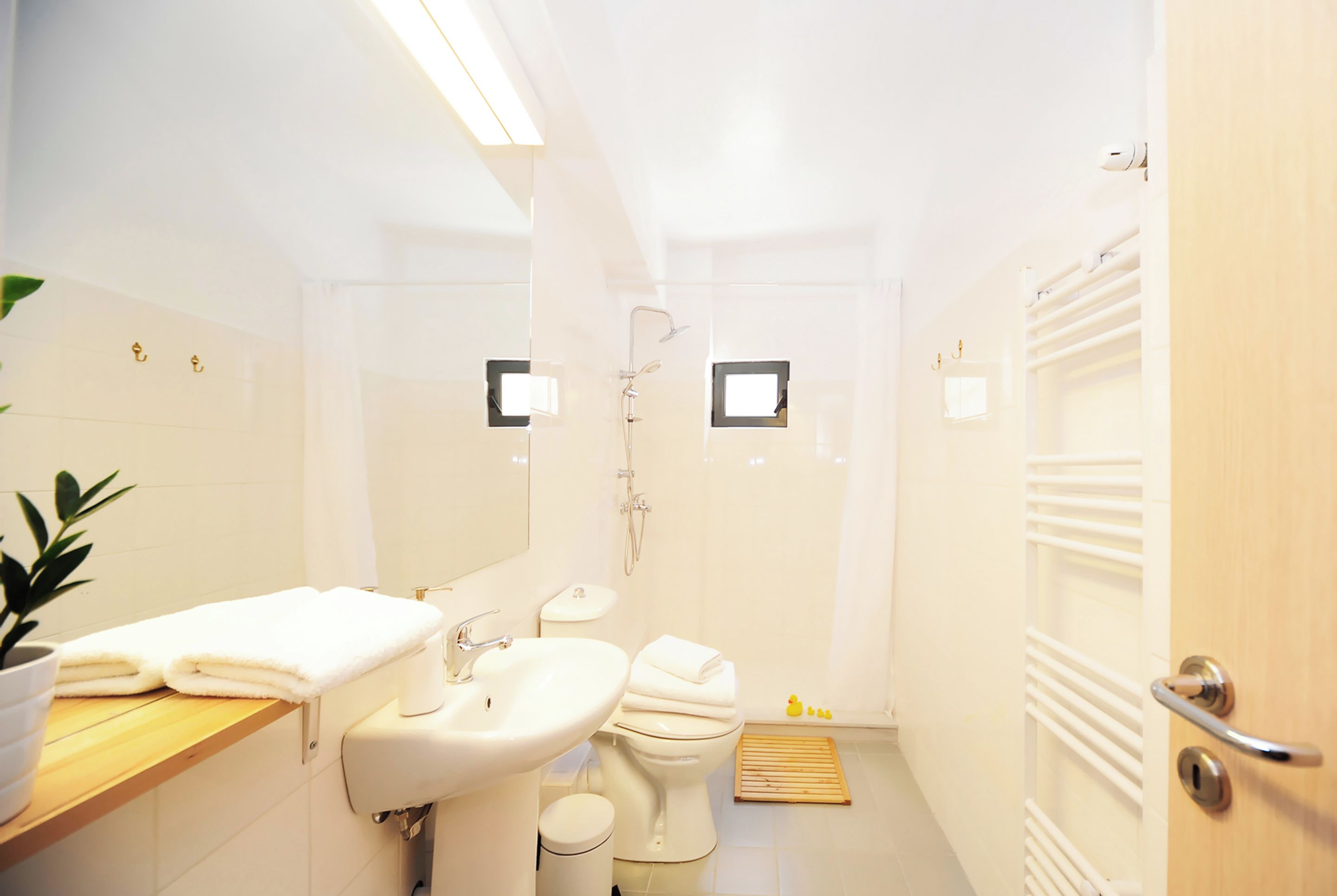 A modern bathroom with a sink, toilet, and shower.
