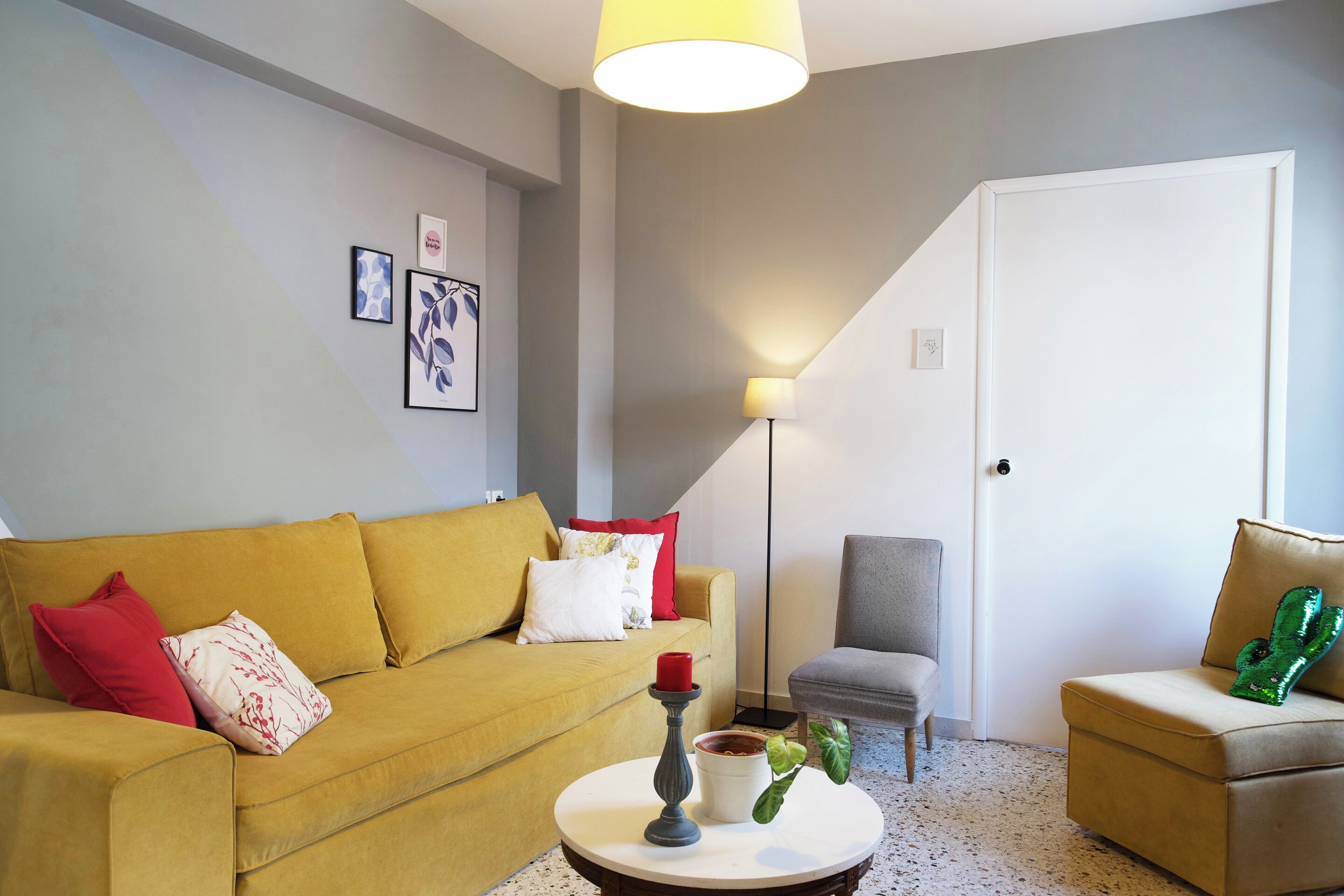 A living room with a sofa, armchairs, a coffee table, and a lamp.