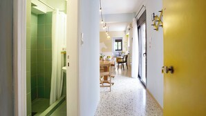A hallway with a shower, a dining area, and a door with a key lock. - Live in Athens, Psyrri Central Apartments (Athens)