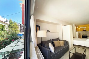 Ein Wohnzimmer mit einer Couch, einer Lampe und Blick ins Freie.