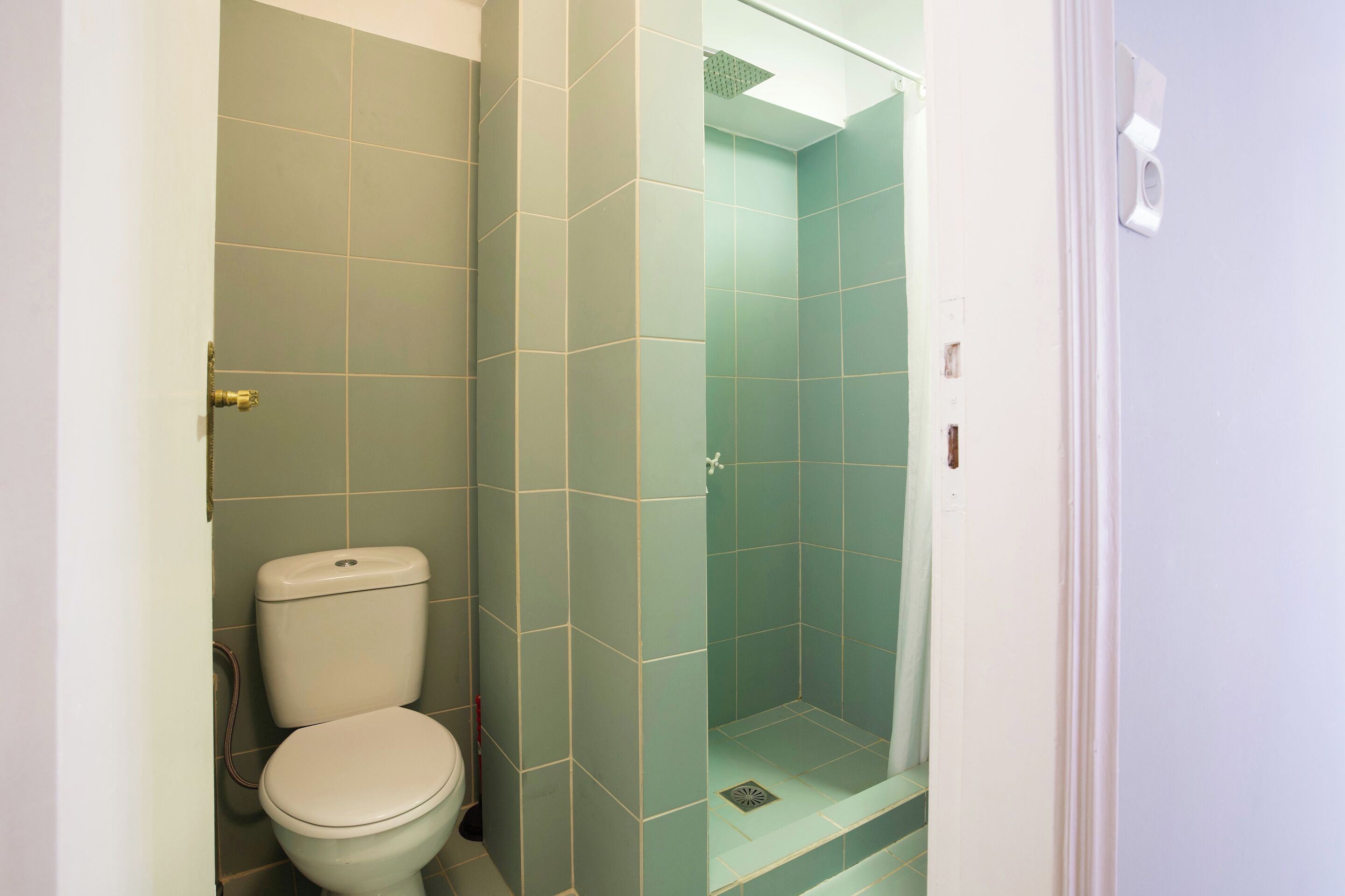 A bathroom with a toilet, a shower, and a sink.