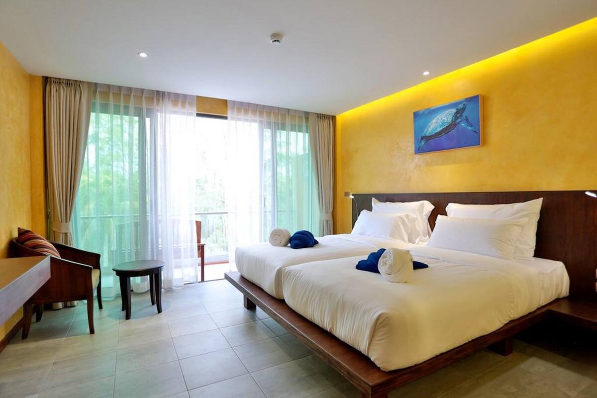 Een hotelkamer met twee bedden, een bureau en een stoel.