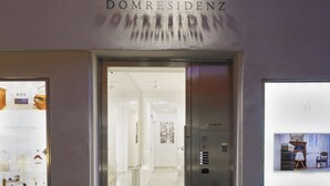 La entrada a un edificio con un letrero que dice 'DOMRESIDENZ APARTMENT SUITES'.