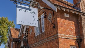A traditional brick building with a sign for 'The Peat Spade Inn' and 'The Bunny' indicating separate rooms or areas. - The Peat Spade Inn (Stockbridge)