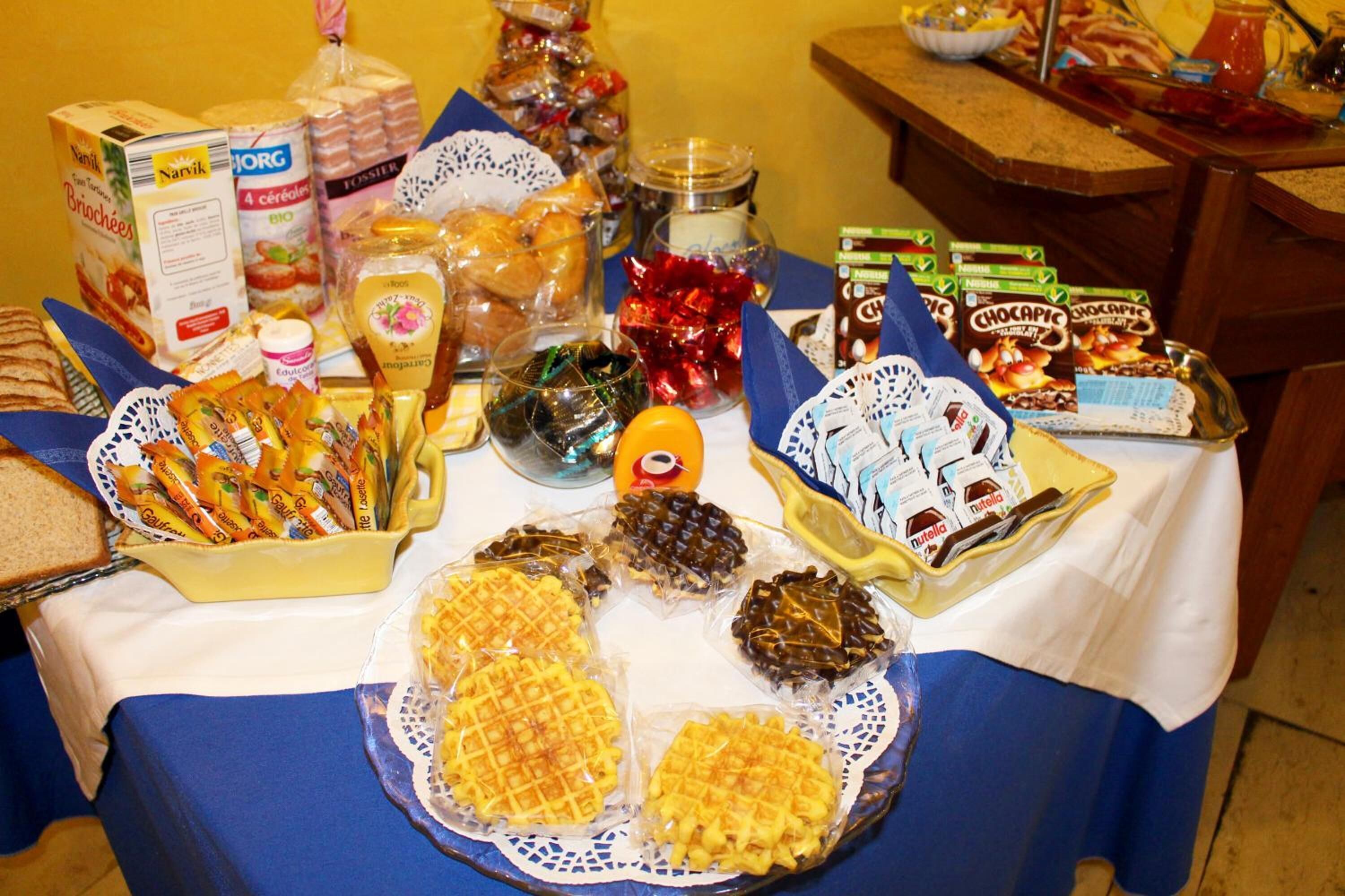 Ein Tisch mit verschiedenen Speisen, darunter Waffeln, Pralinen und Snacks.
