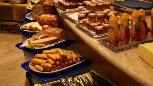 A buffet setup with various food items and condiments. - Les Reflets Jaunes (Givet)