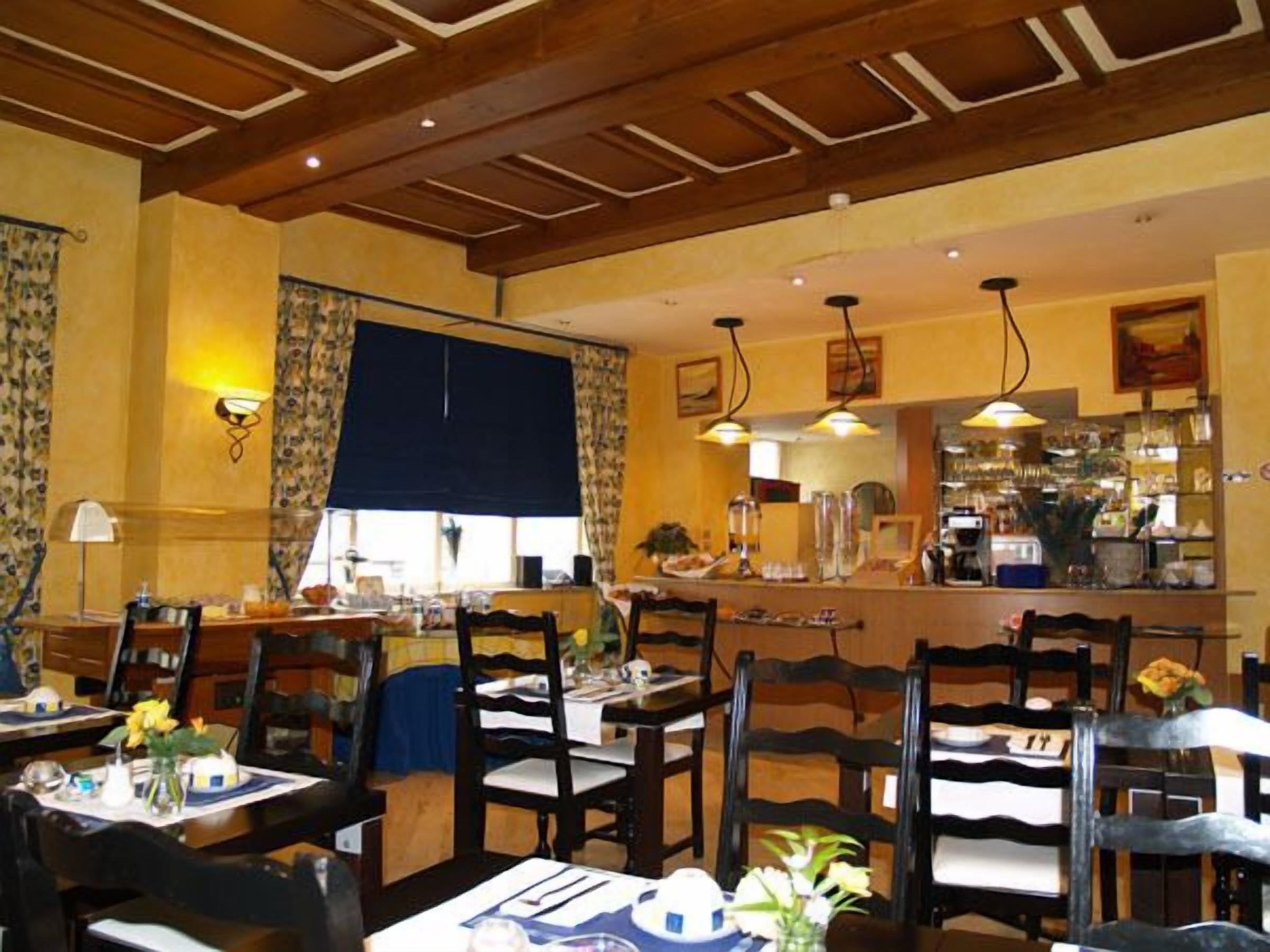A restaurant with wooden ceiling beams, tables with chairs, and a bar area with various items.
