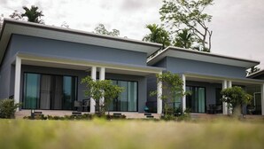 A modern two-story house with large windows, a covered porch, and a well-maintained garden. - Moonlight Cottage (Pa Klok)