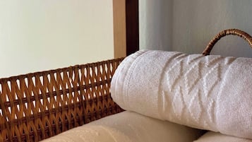 A wicker chair with a white cushion and a handle.