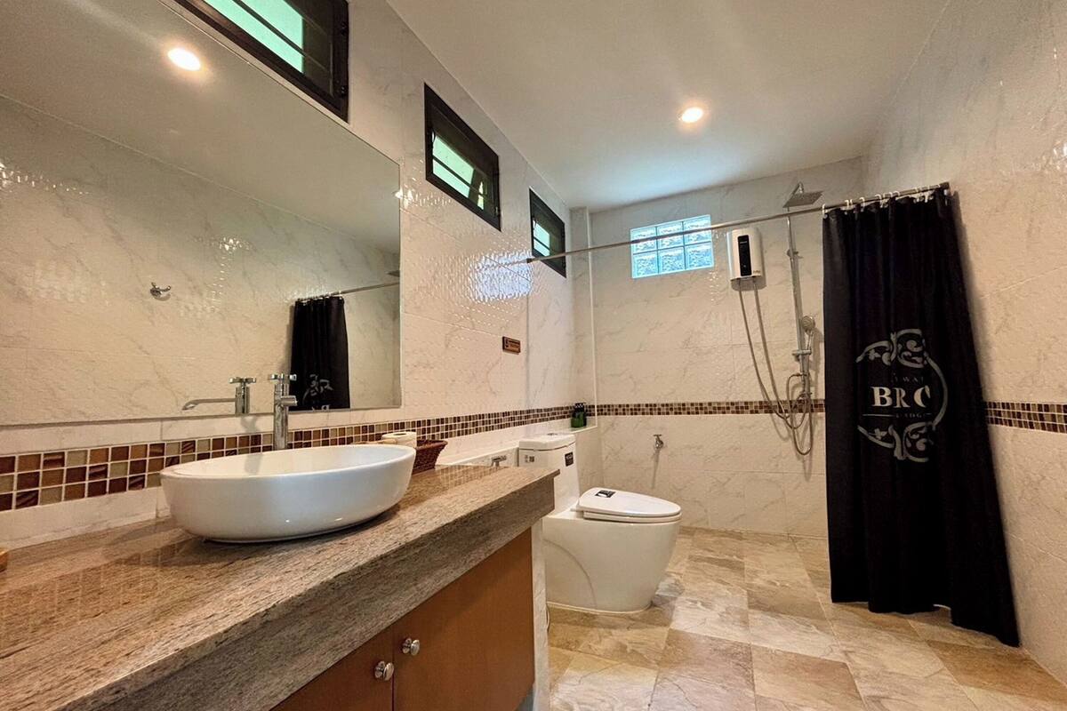 deluxe room | bathroom | shower, free toiletries, hair dryer, slippers