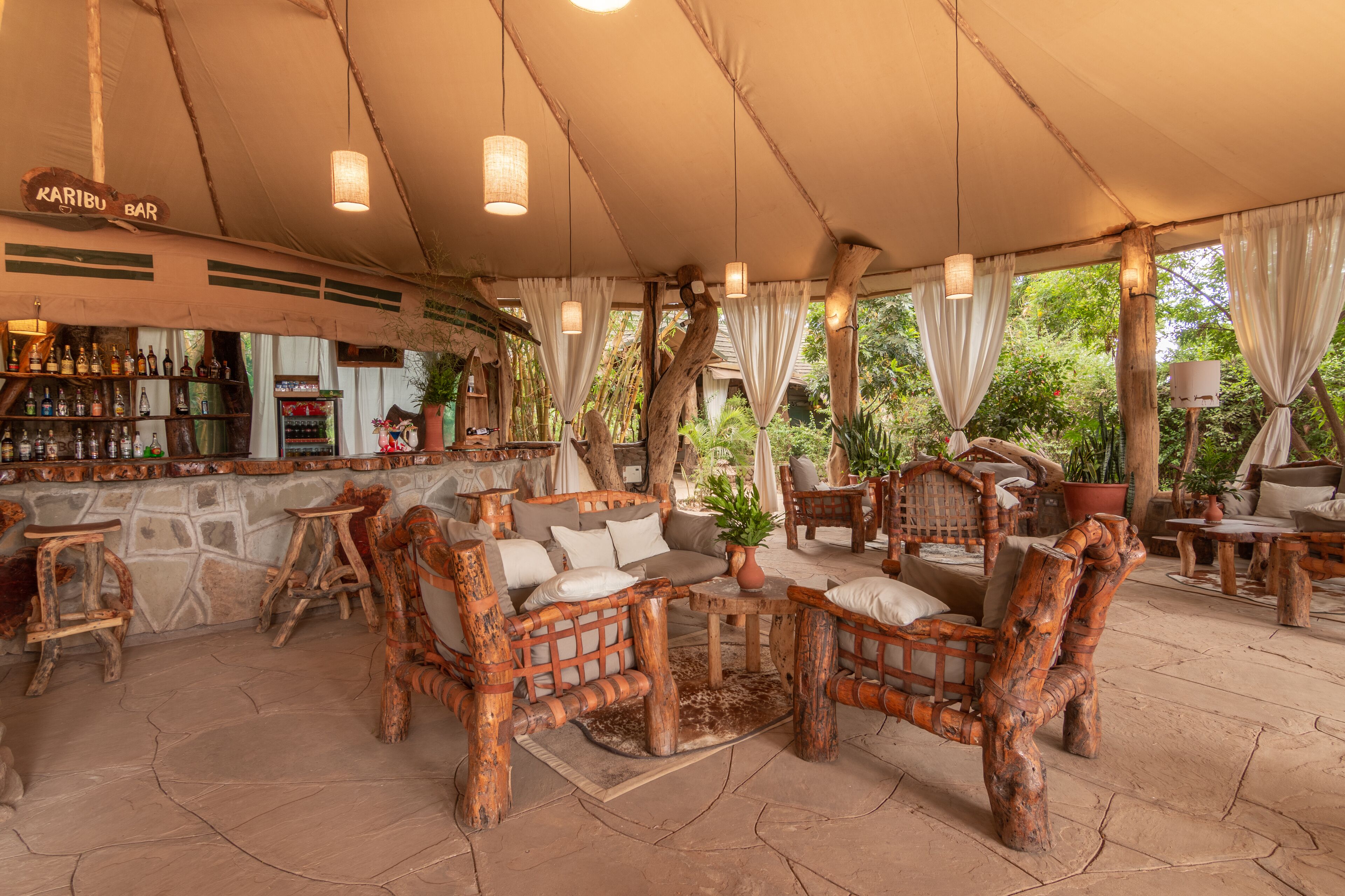 A rustic outdoor seating area with wooden furniture and a bar.