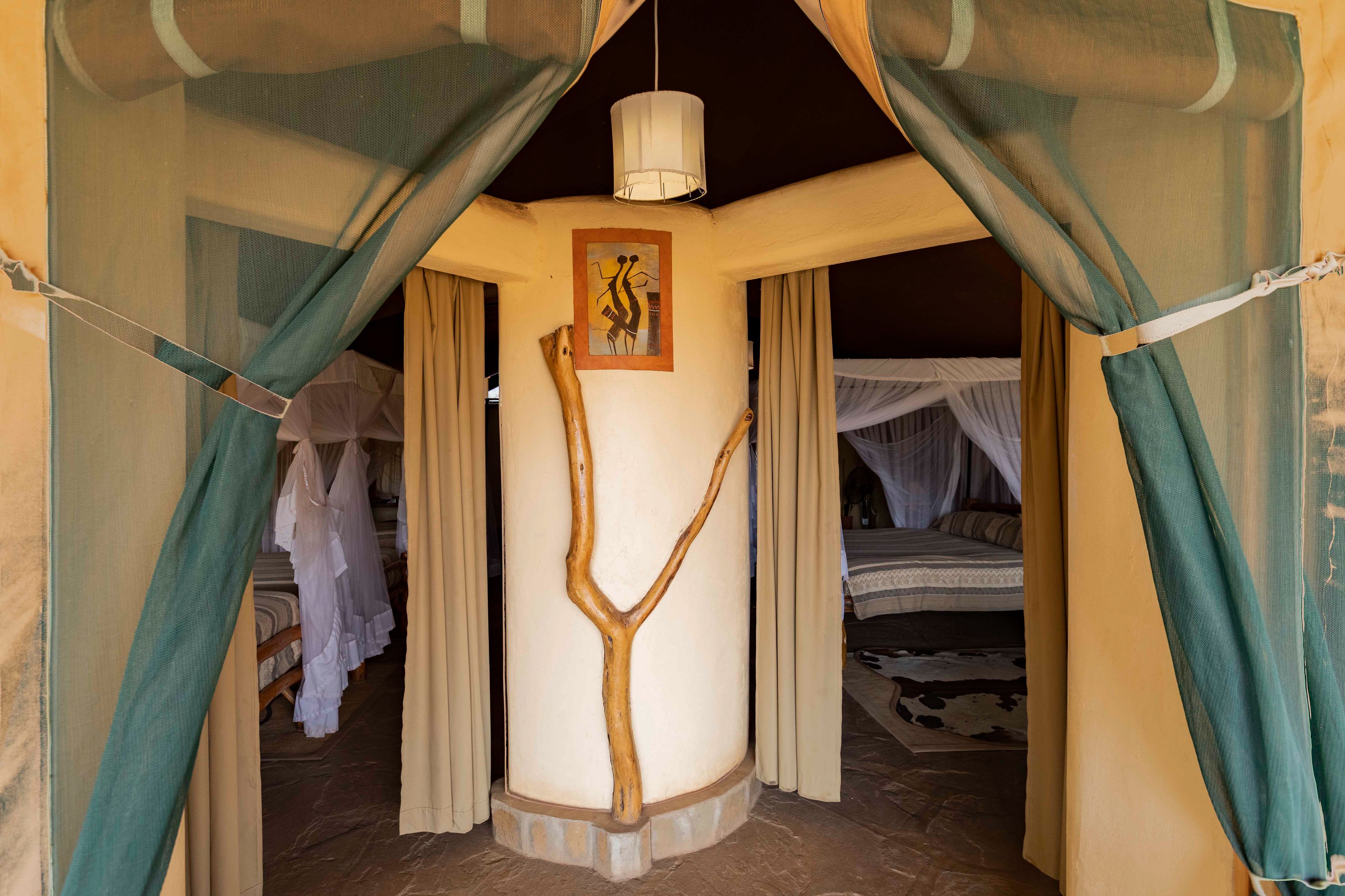 Una habitación con una cama, una lámpara colgante y una escultura con forma de árbol.