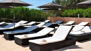 A poolside area with sun loungers and umbrellas. - Résidence Maora Village (Bonifacio)