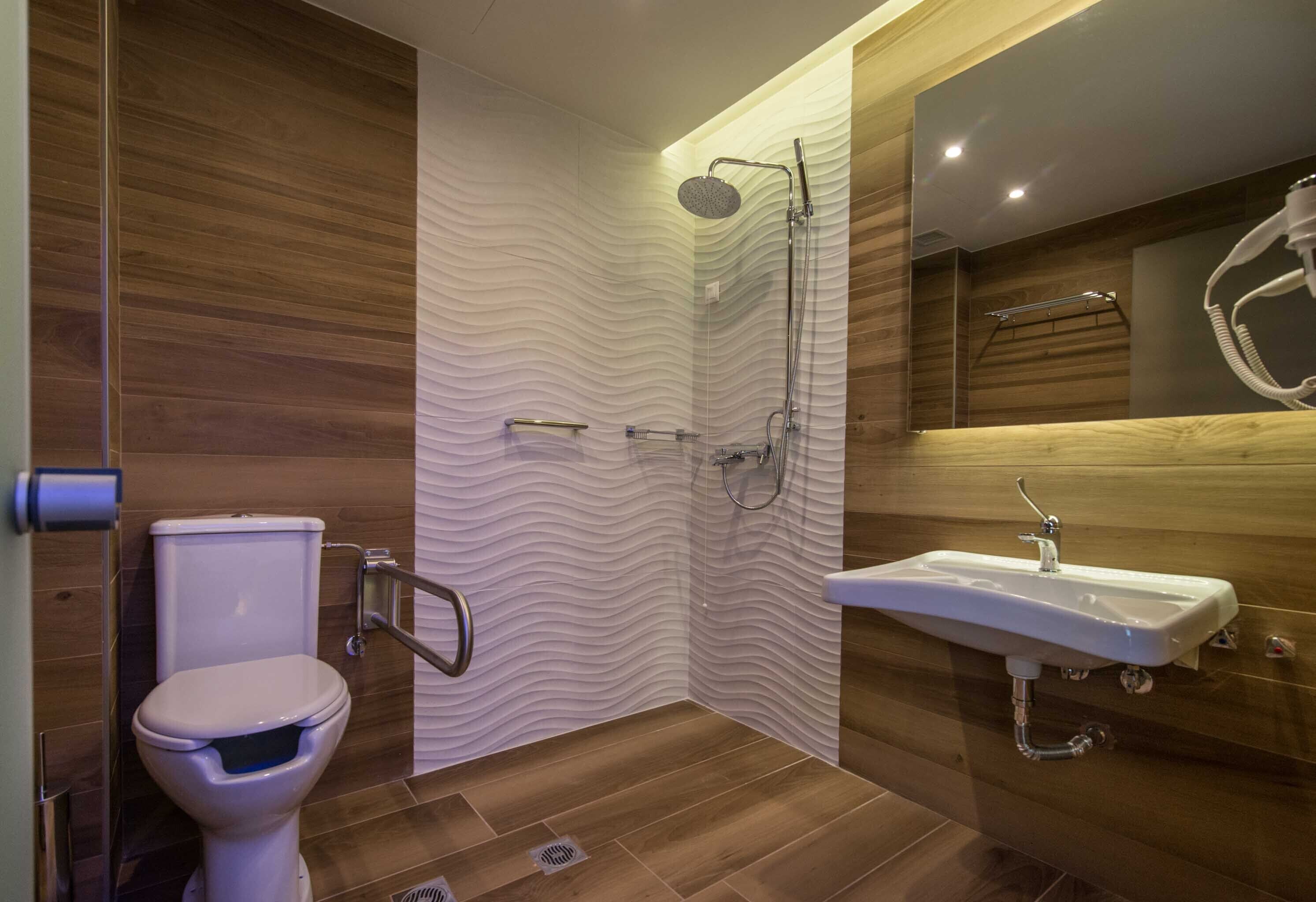 A modern bathroom with a shower, toilet, and sink.