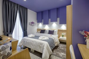 Una camera d'albergo con un letto, comodini, una scrivania e una sedia.