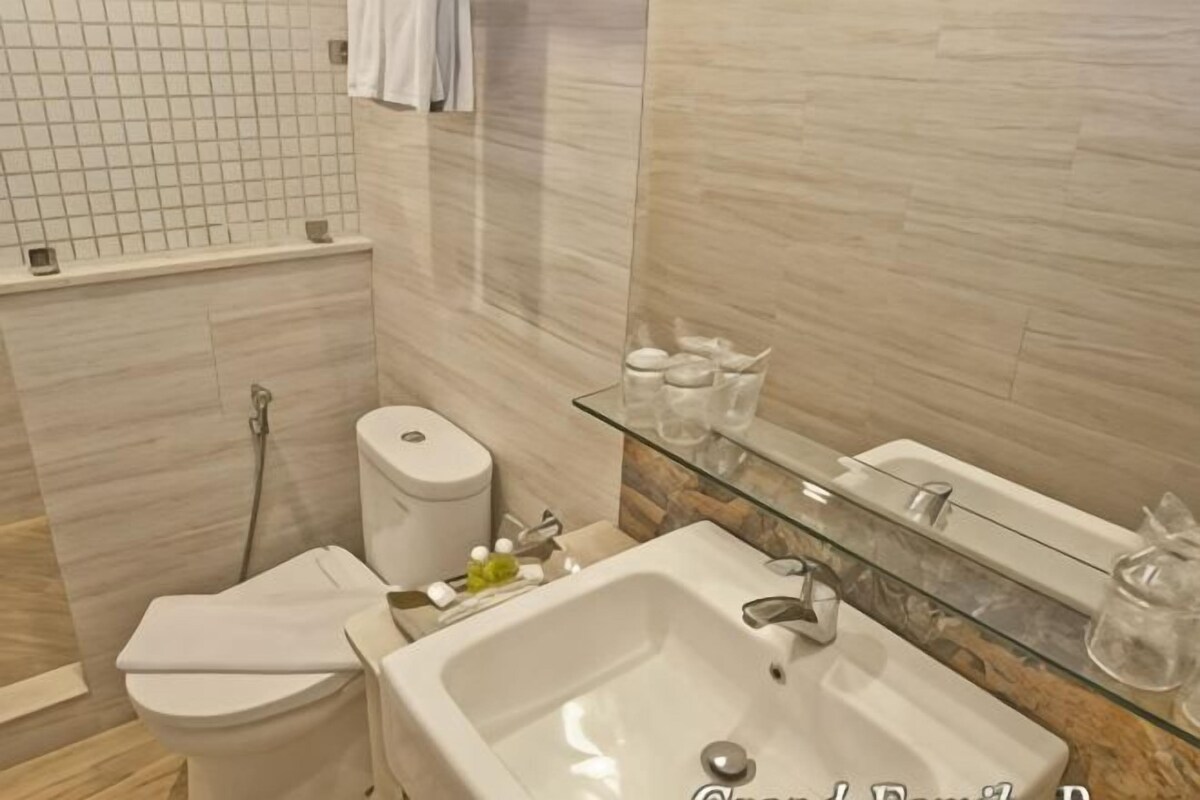 A modern bathroom with a glass shelf, a white toilet, and a large sink.