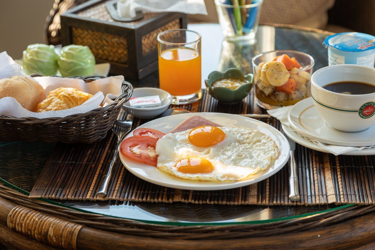 A breakfast tray with eggs, toast, and a glass of orange juice.
