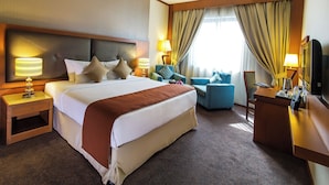 A hotel room with a large bed, two bedside tables, a desk, and a chair. - Landmark Summit Hotel (Dubai)
