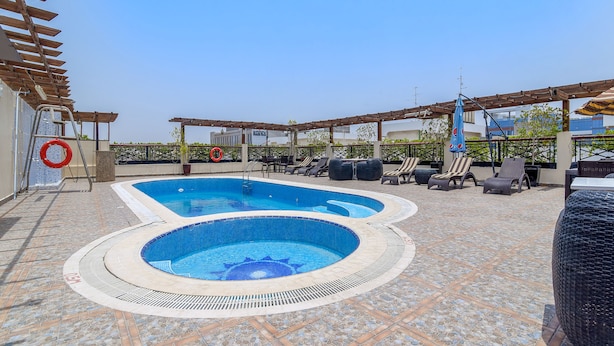 A rooftop swimming pool with a hot tub, lounge chairs, and a pergola. - Landmark Summit Hotel (Dubai)