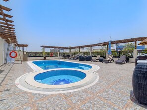 A rooftop swimming pool with a hot tub, lounge chairs, and a pergola. - Landmark Summit Hotel (Dubai)
