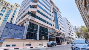 A modern hotel with a prominent entrance, large windows, and a clear sky. - Landmark Summit Hotel (Dubai)