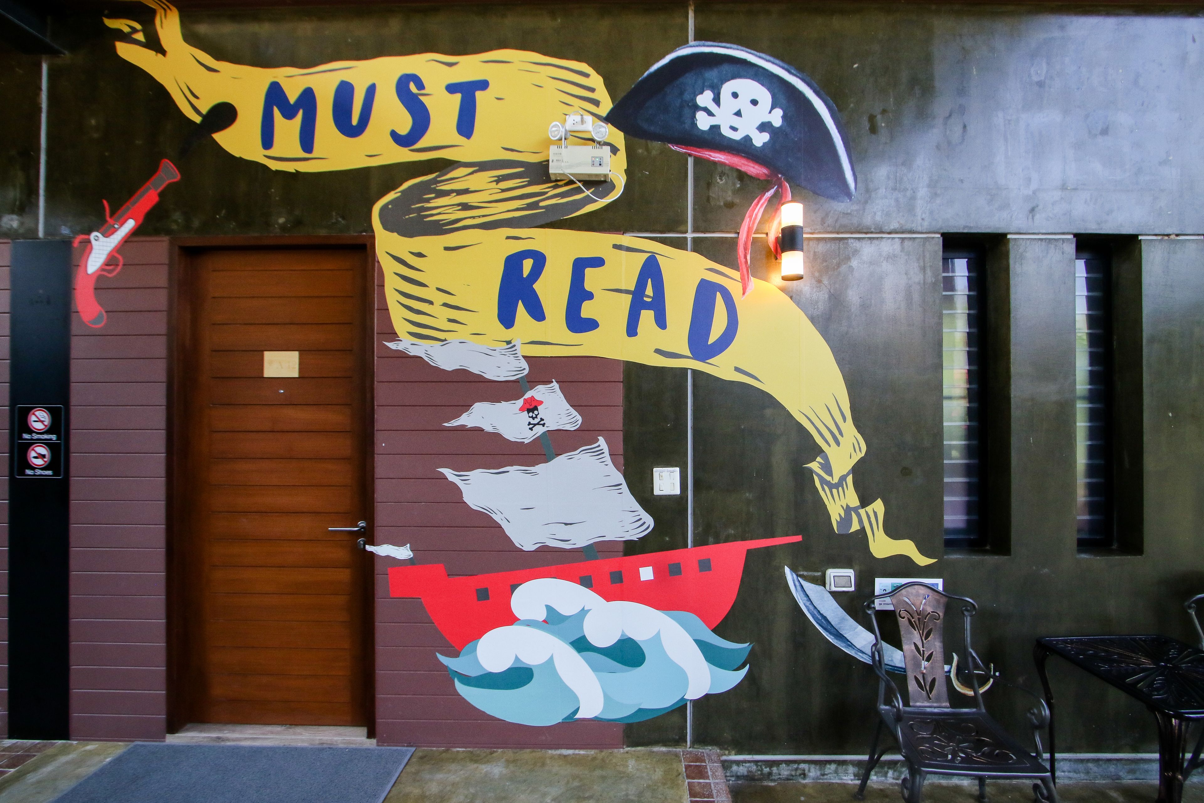 A mural with nautical themes including a ship, a pirate flag, and the words "MUST READ".