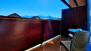 Un balcón con vistas a montañas y un cielo despejado.