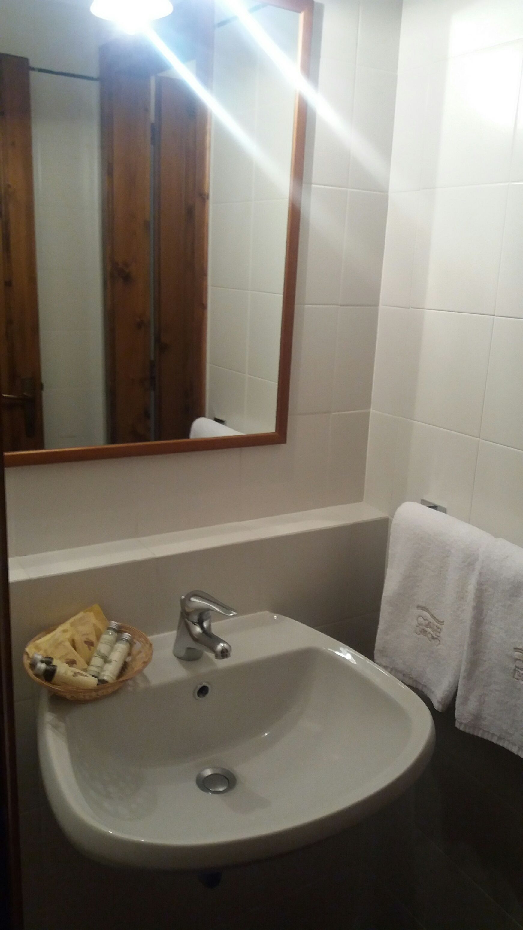 Ein Badezimmer mit Waschbecken, Spiegel und Handtuchhalter.