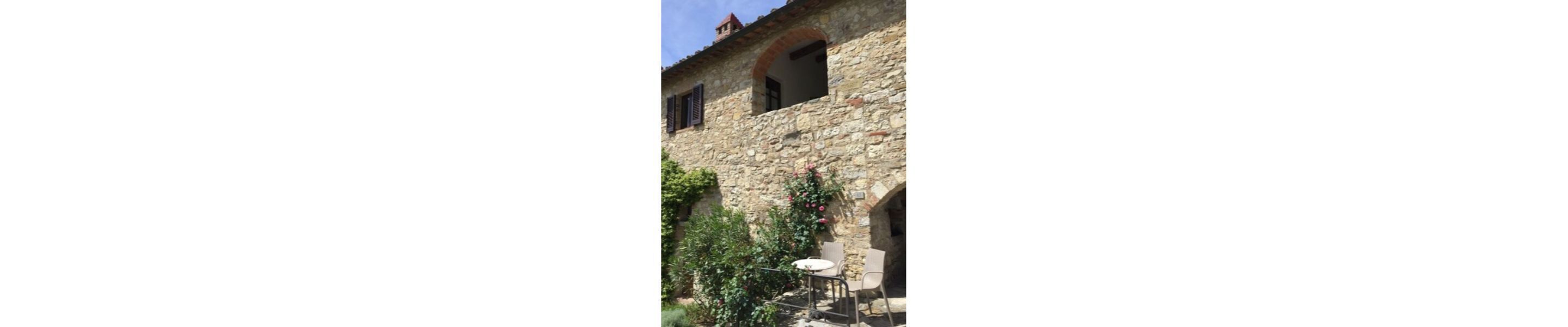 Un edificio de piedra con una ventana y un pequeño balcón.