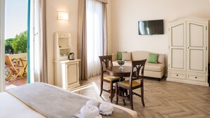 A hotel room with a bed, a dining table with chairs, a sofa, a TV mounted on the wall, and a wardrobe. - Dimora Salviati (Florence)