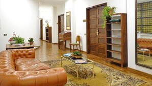 Un salon spacieux avec un canapé en cuir, une table basse et une bibliothèque.